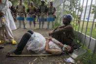 A supporter of Tahir ul-Qadri, a Sufi cleric and leader of Pakistan Awami Tehreek (PAT) party, lies on the ground while soldiers from the Pakistan Rangers block a road leading to Prime Minister Nawaz Sharif's house, during the Revolution March in Islamabad September 1, 2014. REUTERS/Zohra Bensemra