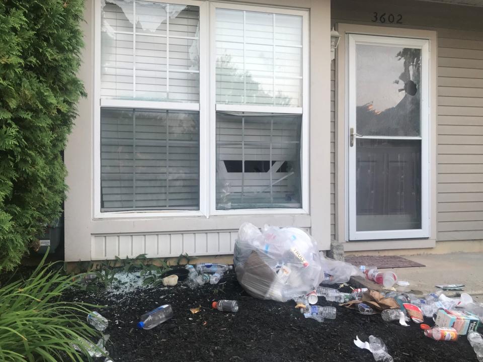 Windows are smashed and lawn is trash-strewn at the house of Edward Cagney Mathews, following his arrest Monday evening.