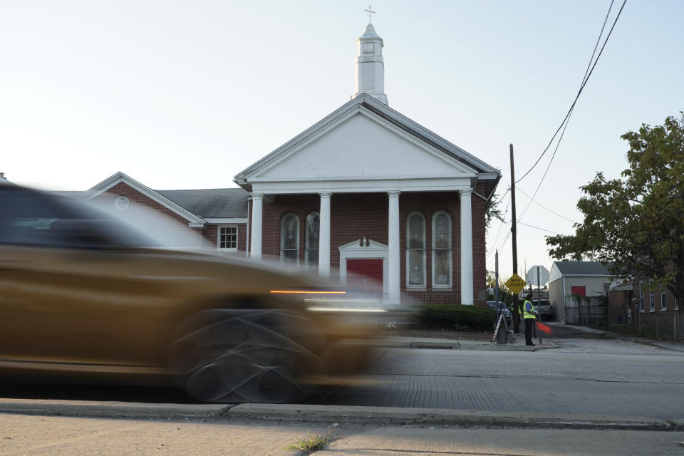 Lisa M. Lewis directs vehicles into the Calvary Baptist Church parking lot which is located near the Philadelphia Union's Subaru Park, Wednesday, Oct. 4, 2023, in Chester, Pa. Across the nation, houses of worship located near stadiums — from Boston’s Fenway Park to the Green Bay Packers’ Lambeau Field — have opened their parking lots to legions of fans. (AP Photo/Michael Perez)