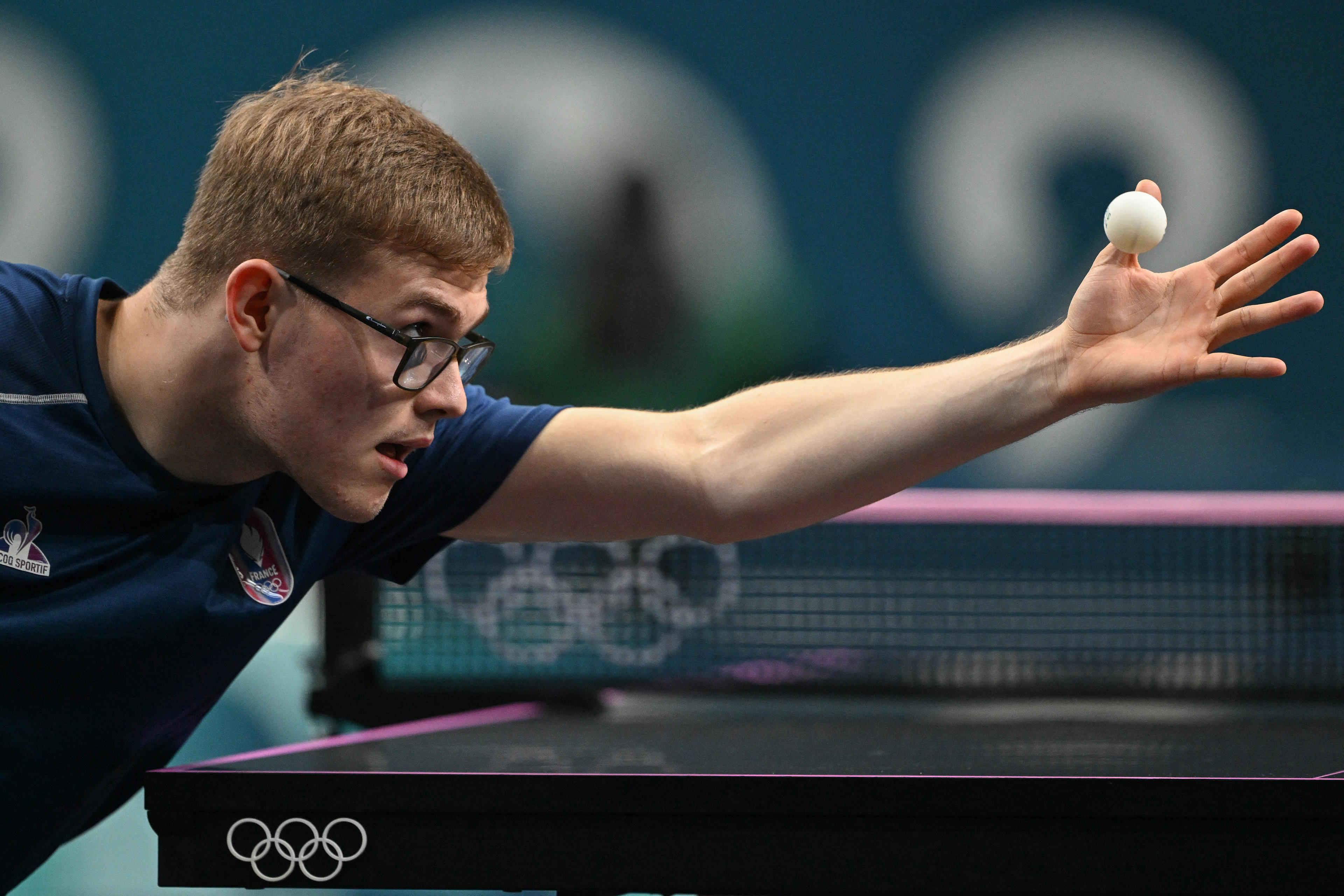 France's Alexis Lebrun eyes the ball while serving during his men's table tennis singles match in the team bronze medal match between France and Japan at the Paris 2024 Olympic Games at the South Paris Arena in Paris on August 9, 2024. (Jung Yeon-je/AFP/Getty Images)