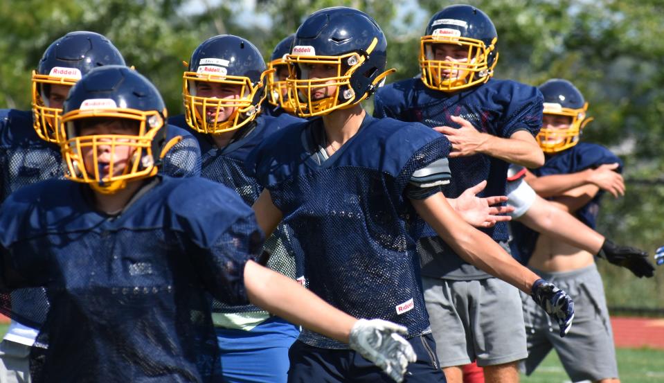 The Atlantis Charter/Bishop Connolly/Westport co-op football team stretches before Wednesday's football practice.