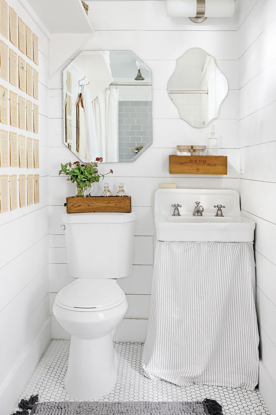 small all white bathroom with hexagon tile floor, shiplap walls, skirted vintage sink, gray subway tile walls in shower