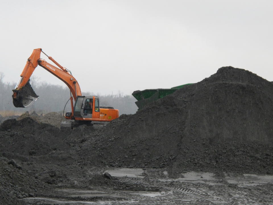 An excavator removes coal ash from the ash pond at Santee Cooper's Jefferies power generating station just outside Moncks Corner, S.C., on Feb. 26, 2014. The recycled coal ash is trucked from the site and then used in the manufacture of concrete. Santee Cooper is South Carolina's state-owned electric and water utility. (AP Photo/Bruce Smith)