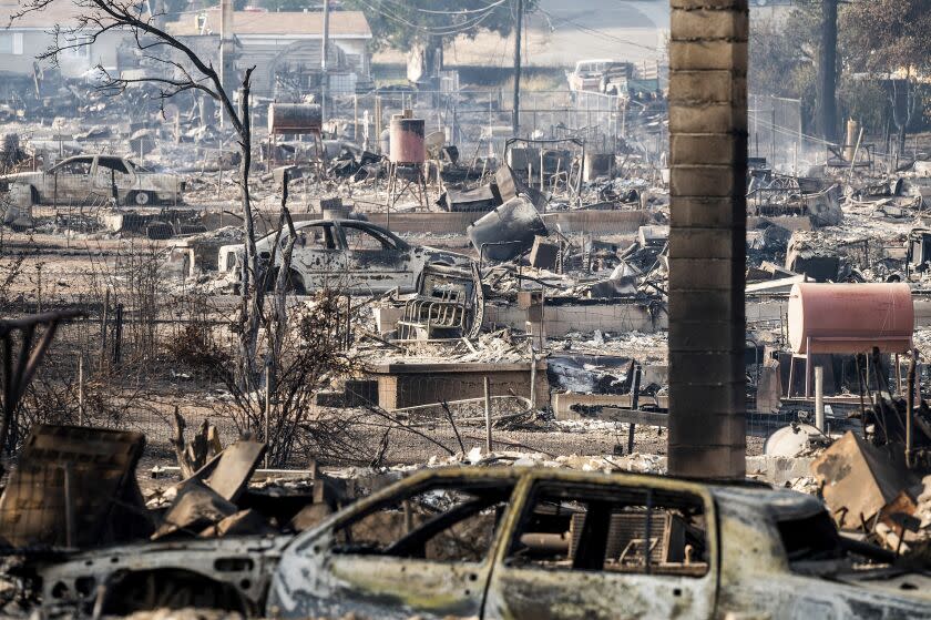 Homes and vehicle destroyed by the Mill Fire line Wakefield Avenue on Saturday, Sept. 3, 2022, in Weed, Calif. (AP Photo/Noah Berger)