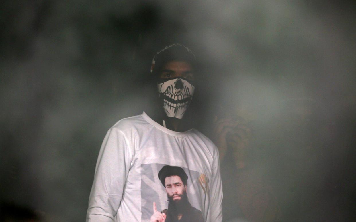 A man wearing a T-shirt with an image of Zakir Musa  - REUTERS