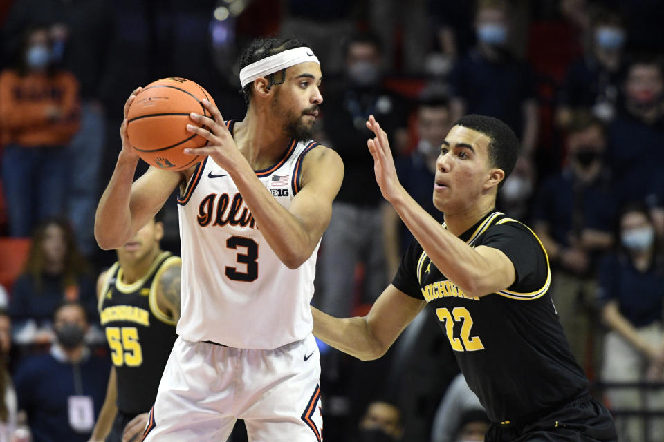 Illinois' Jacob Grandison (3) looks for a passing outlet as Michigan's Caleb Houstan defends during the second half of an NCAA college basketball game Friday, Jan. 14, 2022, in Champaign, Ill. (AP Photo/Michael Allio)