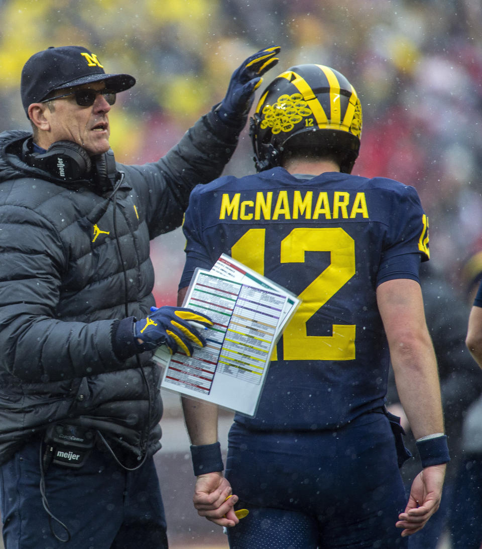 FILE - Michigan head coach Jim Harbaugh pats the helmet of quarterback Cade McNamara (12) after a touchdown in the fourth quarter of an NCAA college football game against Ohio State in Ann Arbor, Mich., Saturday, Nov. 27, 2021. Michigan won 42-27. (AP Photo/Tony Ding, File)