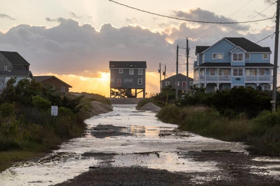 Ocean overwash settles in the street behind beach homes in Rodanthe Friday, Sept, 15, 2023 as Hurricane Lee churns in the Atlantic hundreds of miles offshore.