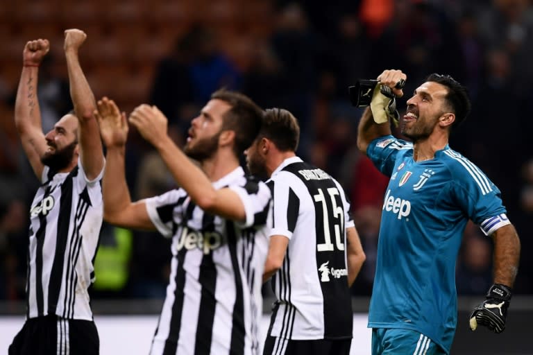 Juventus' goalkeeper Gianluigi Buffon (R) celebrates with teammates at the end of their Italian Serie A match against AC Milan, at the Giuseppe Meazza Stadium in Milan, on October 28, 2017