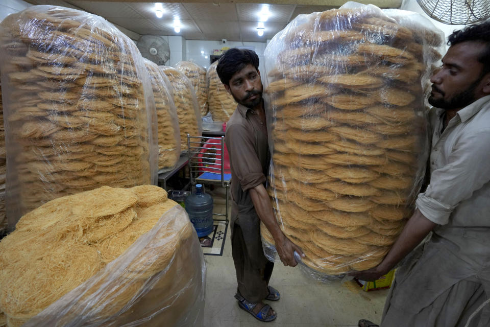 Workers carry vermicelli, a special delicacy prepared for the upcoming Muslim fasting month of Ramadan, in Karachi, Pakistan, Tuesday, March 21, 2023. Muslims across the world will be observing the Ramadan, when they refrain from eating, drinking and smoking from dawn to dusk. Ramadan is expected to officially begin Thursday or Friday in Pakistan, though the timing depends on the alignment of the moon. (AP Photo/Fareed Khan)