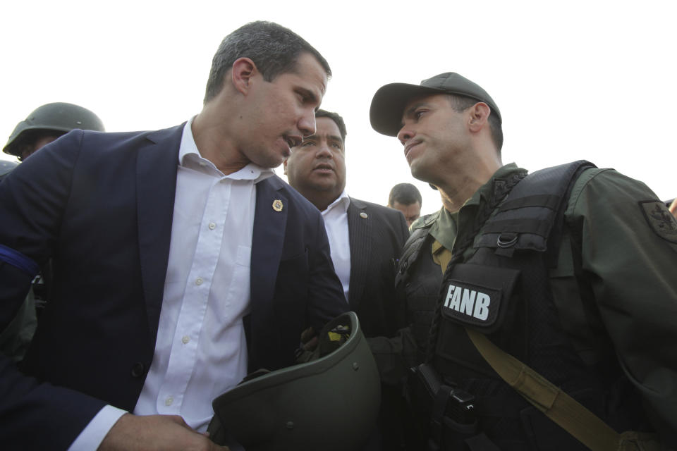 FILE - In this April 30, 2019 file photo, Venezuela's opposition leader and self-proclaimed president Juan Guaido talks to an Army officer outside La Carlota air base in Caracas, Venezuela. Guaido took to the streets with a small contingent of armed soldiers and detained activist Leopoldo Lopez calling for a military uprising. (AP Photo/Boris Vergara, File)