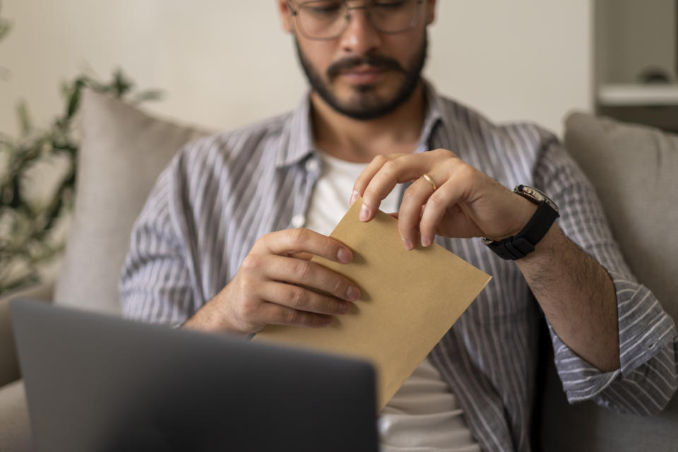 Excited male worker entrepreneur opening mail letter