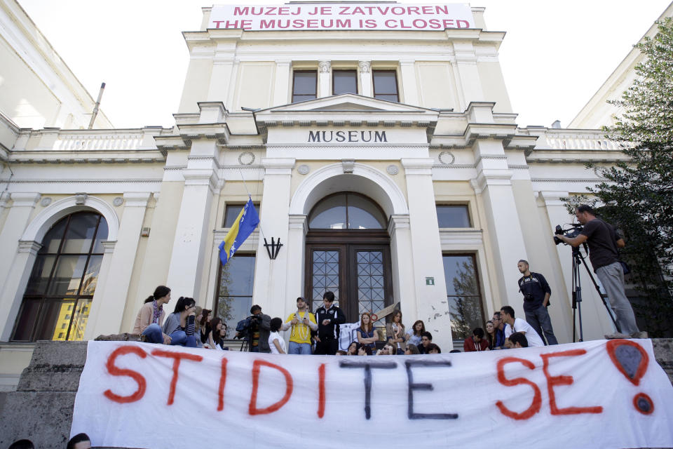 Group of students shout slogans with banner reading "Shame on you" in front of National Museum, in Sarajevo, Bosnia, on Thursday, Oct. 4, 2012. Bosnia's 124 years-old National Museum closed its doors Thursday following disputes among politicians and dwindling state funding, with employees not receiving their salaries for a year.(AP Photo/Amel Emric)