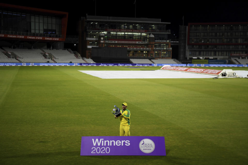 Australia's captain Aaron Finch poses with the winners trophy after their win in the third ODI cricket match between England and Australia, at Old Trafford in Manchester, England, Wednesday, Sept. 16, 2020. (Shaun Botterill/Pool via AP)