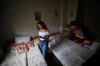 Tatiana Hasrouty uses her mobile phone next to the bed of her father Ghassan Hasrouty, a missing silo employee, following Tuesday's blast in Beirut's port area