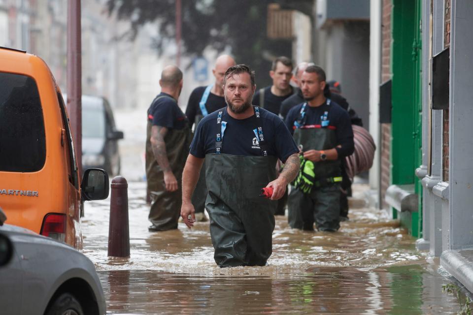 Emergency workers wade through the water in Ensival (EPA)