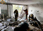 In this photo provided by the Ukrainian Emergency Service, first responders work in a damaged residential building in Odesa, Ukraine, early Friday, July 1, 2022, following Russian missile attacks. Ukrainian authorities said Russian missile attacks on residential buildings in the port city of Odesa have killed more than a dozen people. (Ukrainian Emergency Service via AP)