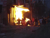 A shop burns as a mob sets it on fire during violence between two groups in New Delhi, India, Tuesday, Feb. 25, 2020. At least 23 people were killed in three days of clashes that cast a shadow over U.S. President Donald Trump's visit to the country. (AP Photo)