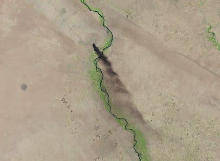 A U.S. Geological Survey satellite image shows smoke rising from the Baiji refinery near Tikrit, Iraq, June 18, 2014 in this handout provided by U.S. Geological Survey. REUTERS/Landsat data courtesy of the U.S. Geological Survey/Handout via Reuters