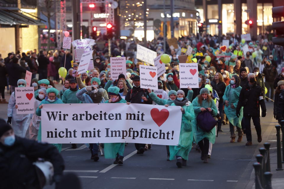 Demonstranten protestieren mit einem Banner mit der Aufschrift „Wir arbeiten mit Herz nicht mit Impfpflicht“ gegen die Corona-Politik.