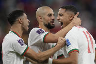 Morocco's Abdelhamid Sabiri, right, celebrates after scoring his side's opening goal with team mates Achraf Hakimi, left, and Sofyan Amrabat during the World Cup group F soccer match between Belgium and Morocco, at the Al Thumama Stadium in Doha, Qatar, Sunday, Nov. 27, 2022. (AP Photo/Christophe Ena)