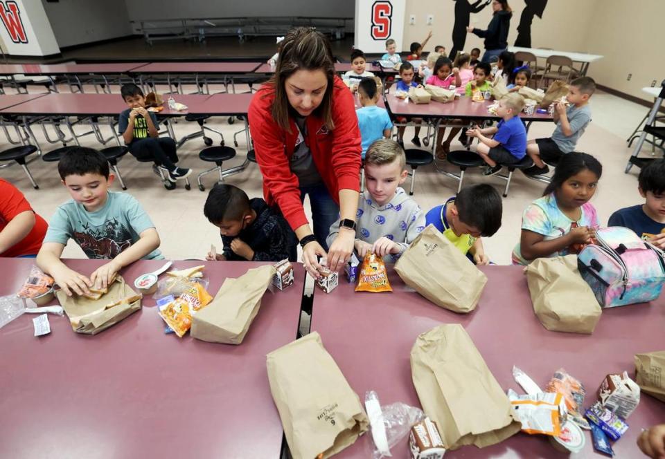 Sam Houston Elementary principal Jacy Roach, center, helps students with their lunch during a catch-up day on Friday, April 14, 2023. Mineral Wells ISD shifted to a four-day school week this year, but offered a catch-up day on Fridays for students who needed extra help, or for parents who needed a place to send their kids while they’re at work.