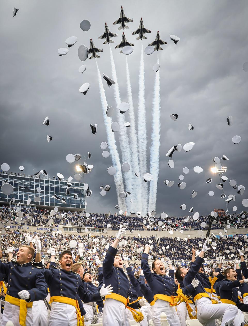 Air Force Academy cadets celebrate graduation as the Thunderbirds fly over Falcon Stadium on June 1, 2023, on the grounds of the U.S. Air Force Academy in Colorado Springs, Colorado.