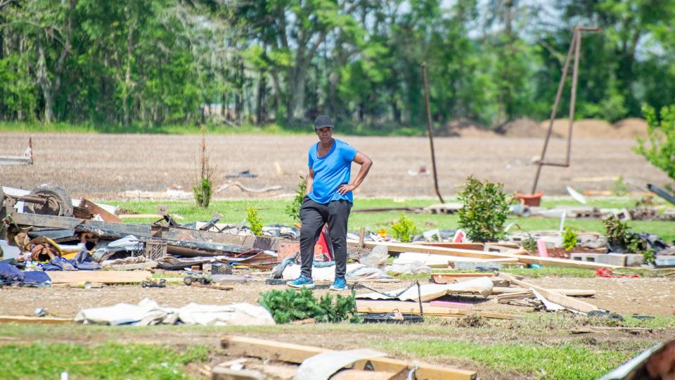 Gladus Johnson surveys the damage left behind by a deadly tornado in St. Landry Parish.