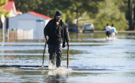 People tread over flooded streets following Hurricane Matthew in Lumberton, North Carolina, U.S., October 10, 2016. REUTERS/Carlo Allegri