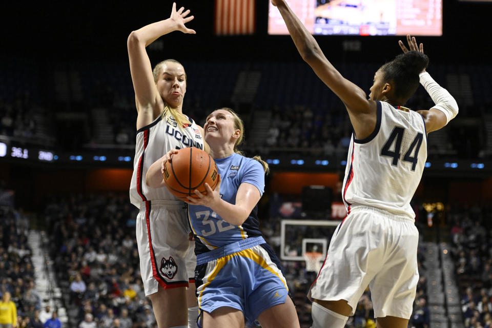 Marquette's Liza Karlen (32) splits between Connecticut's Dorka Juhasz and Aubrey Griffin (44) during the first half of an NCAA college basketball game in the semifinals of the Big East Conference tournament at Mohegan Sun Arena, Sunday, March 5, 2023, in Uncasville, Conn. (AP Photo/Jessica Hill)