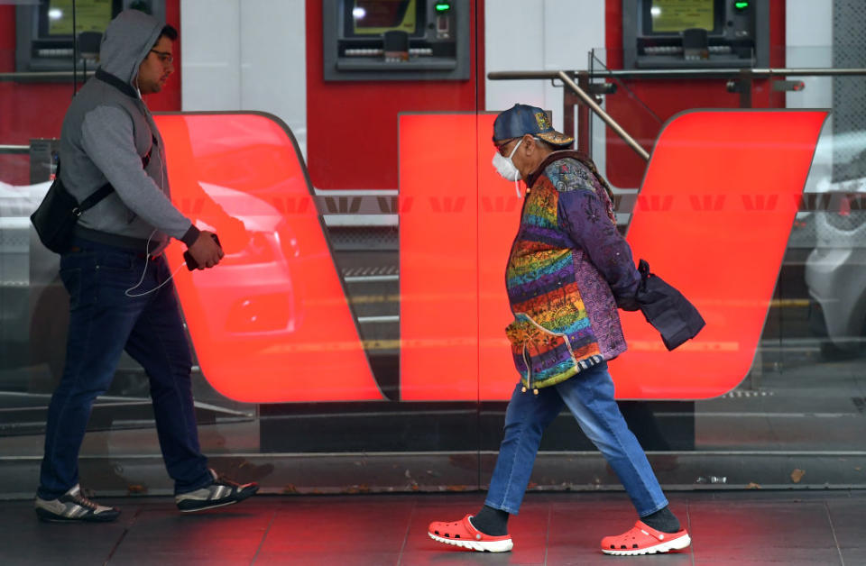 Pedestrians walk past a Westpac branch with a huge Westpac logo