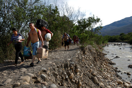 Venezuelans carry their belongings along a pathway after illegally entering Colombia through the Tachira river close to the Simon Bolivar International bridge in Villa del Rosario, Colombia August 25, 2018. REUTERS/Carlos Garcia Rawlins