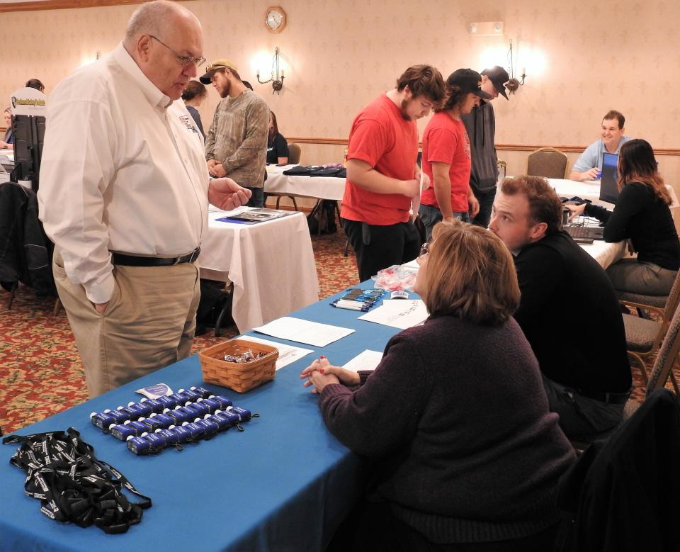 Lynn Jacobs, director of Ohio Means Jobs of Coshocton County, talks with representatives of Coshocton Regional Medical Center at a job fair at Coshocton Village Inn and Suites.