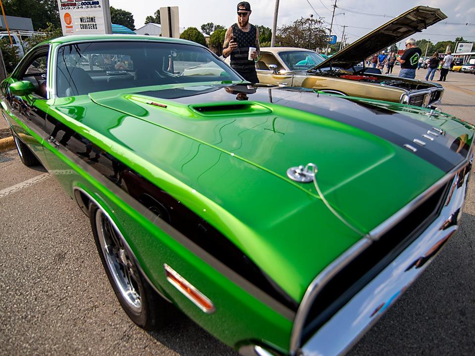 Bobby Downs of Peoria takes a cell phone photo of a 1970 Dodge Challenger owned by Tyler Walters of Knoxville during the Maple City Street Machines Cruise In on Friday, Aug. 6, 2021 in Monmouth.