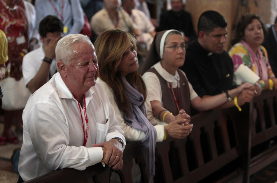 Cuban-American, Nestor Machado, left, and other Cuban-American pilgrims pray at the Virgen del Cobre Church in Santiago de Cuba, Cuba, Monday March 26, 2012. More than 300 Cuban-Americans and other pilgrims have arrived in Cuba for Pope Benedict XVI's visit on a trip led by Miami Archbishop Thomas Wenski.(AP Photo/Esteban Felix)