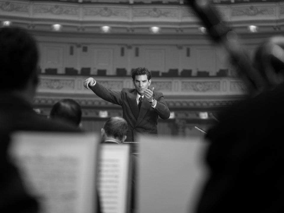 A young Leonard Bernstein (Bradley Cooper) conducts the New York Philharmonic in the musical drama "Maestro."