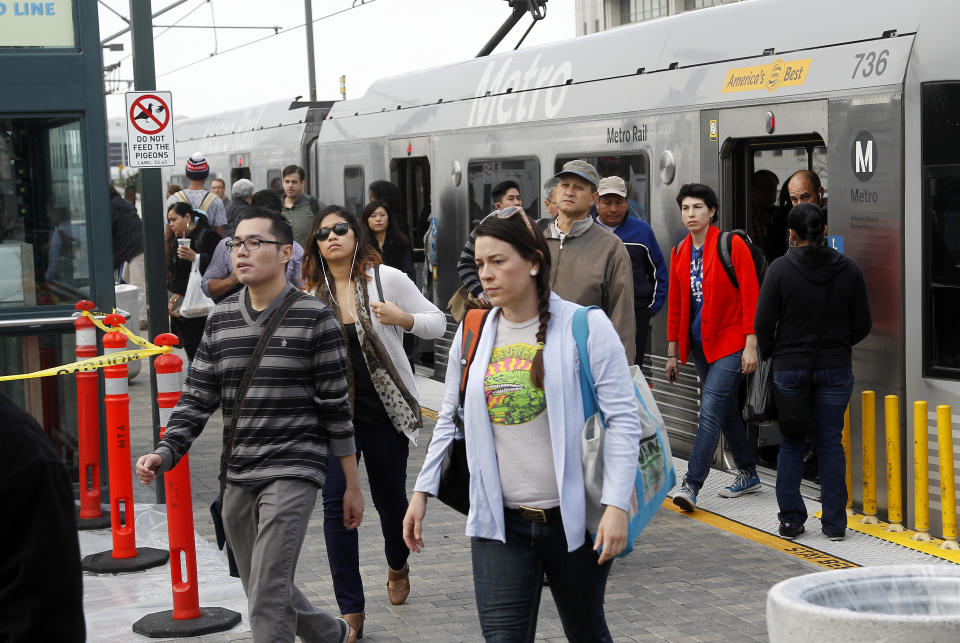 Pedestrians disembark from a train at Union Station Friday March 7, 2014 in Los Angeles. Americans are boarding public buses, trains and subways in greater numbers than any time since the suburbs began to boom. Nearly 10.7 billion trips in 2013, to be precise, the highest number since 1956. (AP Photo/Nick Ut)