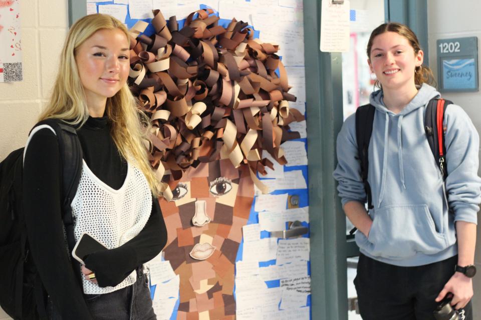 Barnstable High School students Paisley Powers (left) and Grace Condinho worked with other students to create their Black History Month classroom door project, which included hundreds of quotes influenced by novels about Black history they are reading in class. The project also included a wall of fame featuring Time magazine covers of Black historical figures.