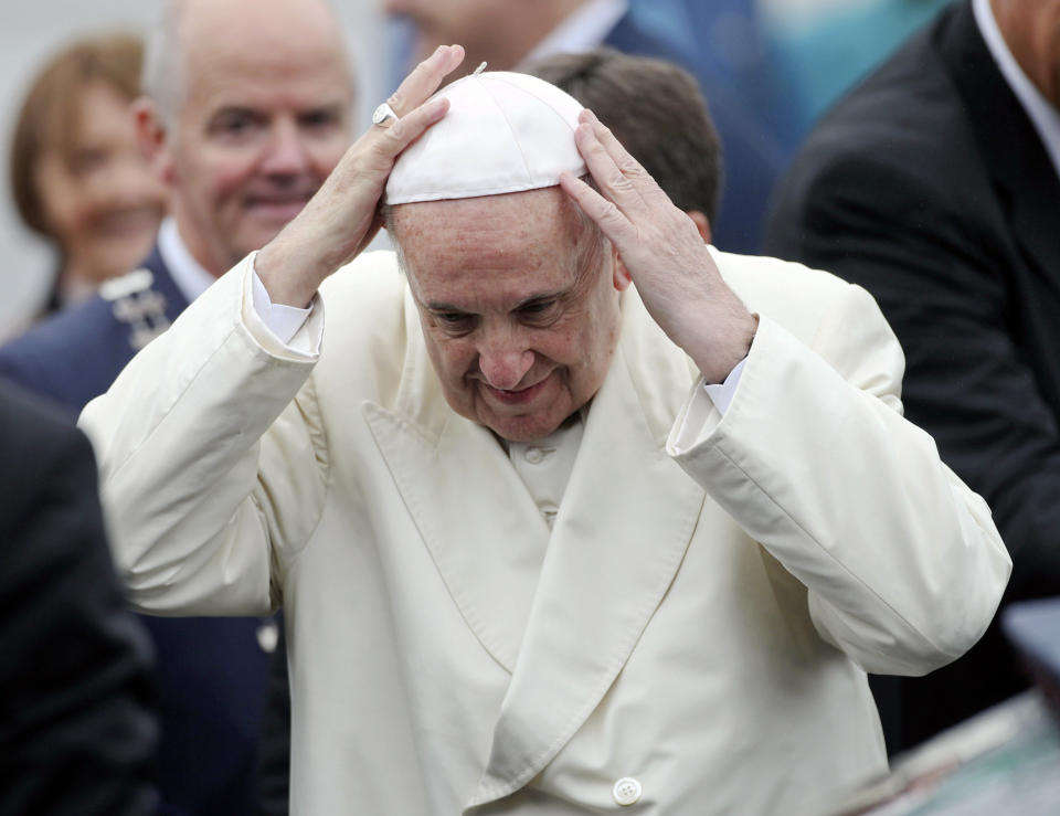 Pope Francis adjusts his cap as he disembarks from an airplane at Knock's airport, Ireland, where he will visit the Knock Shrine and recite an angelus prayer, Sunday, Aug. 26, 2018. Pope Francis is on a two-day visit to Ireland. (Yui Mok/PA via AP)