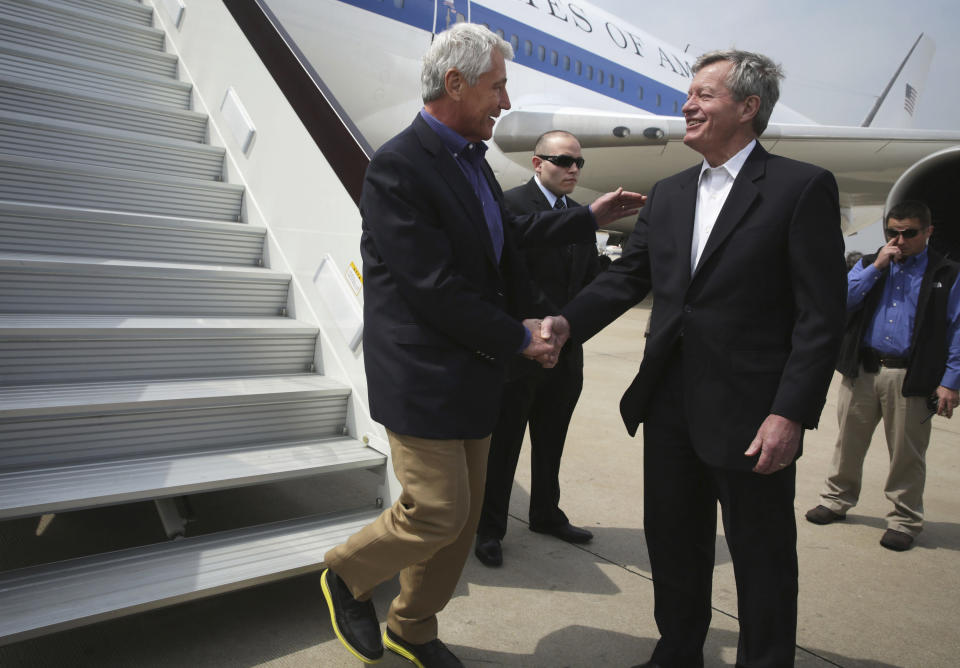 U.S. Secretary of Defense Chuck Hagel, left, is welcomed by U.S. Ambassador to China Max Baucus upon his arrival at Qingdao International Airport in Qingdao, China, Monday, April 7, 2014. Hagel is currently on his fourth trip to Asian nations since taking office. (AP Photo/Alex Wong, Pool)