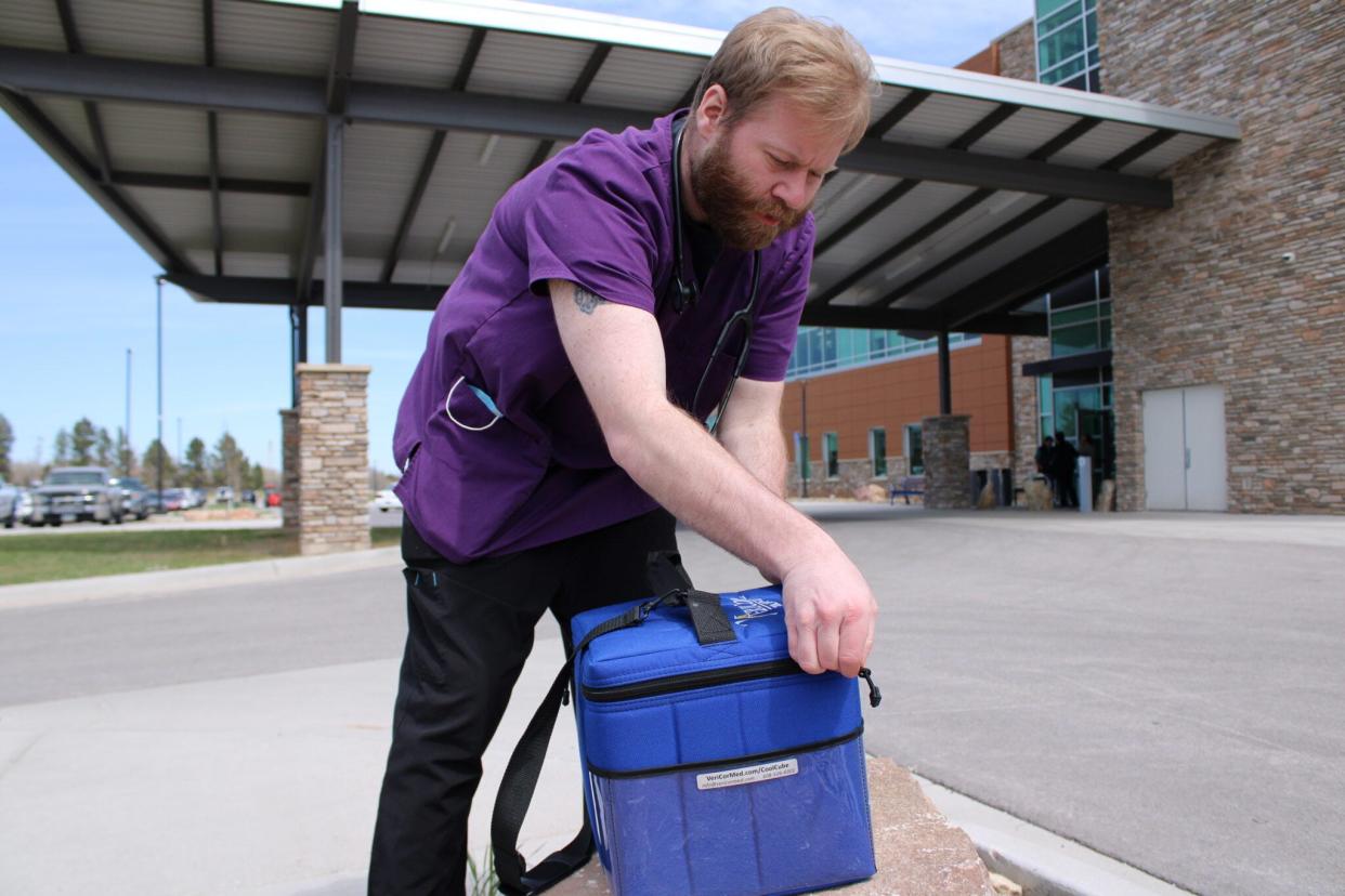 Tyler Broghammer, a sexually transmitted infection caseworker, opens a cooler filled with syringes of penicillin on April 24, 2024, at Oyate Health Center in Rapid City.