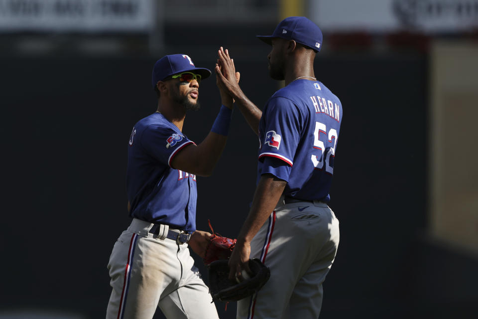 Texas Rangers' Leody Taveras, left, celebrates with Taylor Hearn, right, after defeating the Minnesota Twins in a baseball game, Sunday, Aug. 21, 2022, in Minneapolis. (AP Photo/Stacy Bengs)