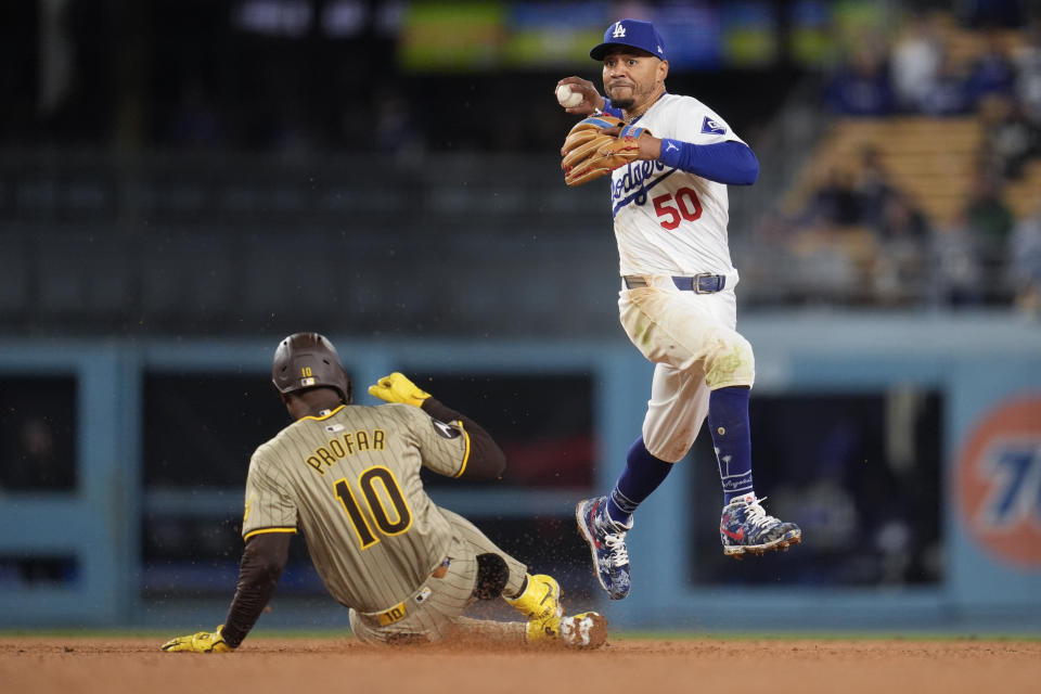 San Diego Padres' Jurickson Profar (10) is out at second base under Los Angeles Dodgers shortstop Mookie Betts during the ninth inning of a baseball game Saturday, April 13, 2024, in Los Angeles. (AP Photo/Marcio Jose Sanchez)