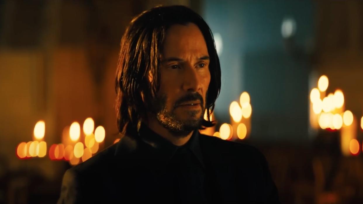  Keanu Reeves as John Wick in cathedral surrounded by lit candles 