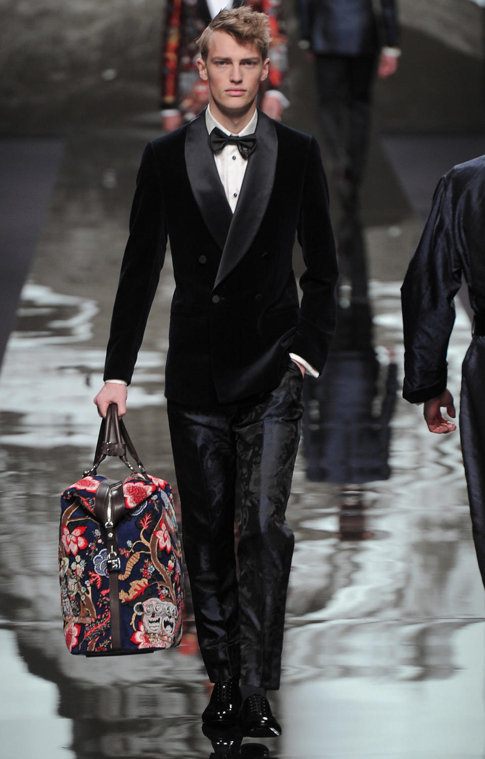 <p>Model wears a smooth midnight blue velvet blazer with printed trousers and colorful weekender bag. <br> (Photo: Catwalking) </p>