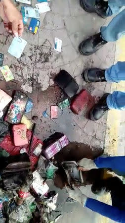 Sanitation workers retrieve wallets from a drain, after local media reported that a stash of wallets were clogging a canal in Poblacion, Batangas City, Philippines October 16, 2018, in this still image taken from a video obtained from social media. Domav Panganiban/via REUTERS