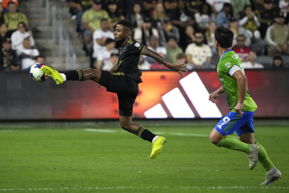 Los Angeles FC defender Diego Palacios, left, kicks the ball as Seattle Sounders forward Heber chases during the second half of a Major League Soccer match Wednesday, June 21, 2023, in Los Angeles. (AP Photo/Mark J. Terrill)