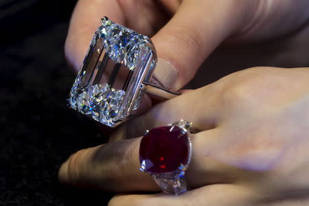 A model displays both a 100.20 carats (top) and a 25.59 carats, that is known as 'The Sunrise Ruby', diamond rings at a pre-auction viewing at Sotheby's in Hong Kong April 3,2015. REUTERS/Tyrone Siu