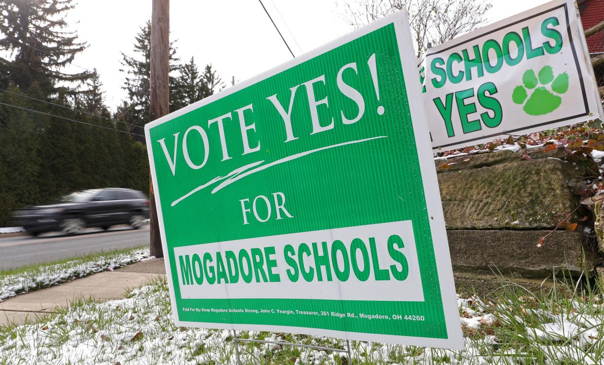 Signs in support of the Mogadore Local School District's tax levy stand on the corner of South Cleveland Avenue and Prospect Street in Mogadore on Tuesday, March 19, 2024. The tax issue failed in Tuesday's primary election vote.