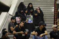 Followers of Shiite cleric Muqtada al-Sadr hold posters with his photo during a sit-in, inside the parliament in Baghdad, Iraq, Monday, Aug. 1, 2022. The political rivals of al-Sadr whose followers stormed the parliament have declared their own counter-protest. The announcement on Monday stirred fear among Iraqis and caused security forces to erect concrete barriers leading to the heavily fortified Green Zone, home of the parliament building. (AP Photo/Anmar Khalil)